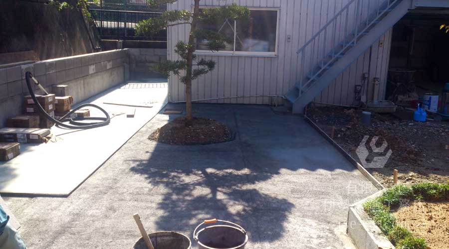 地面を水平にするため大きな石を取り除きコンクリートで固める作業