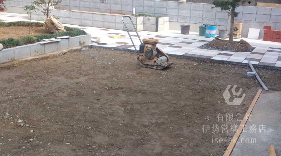 コンクリートが固まった箇所からタイル張りを開始し、転圧機で地面を固める